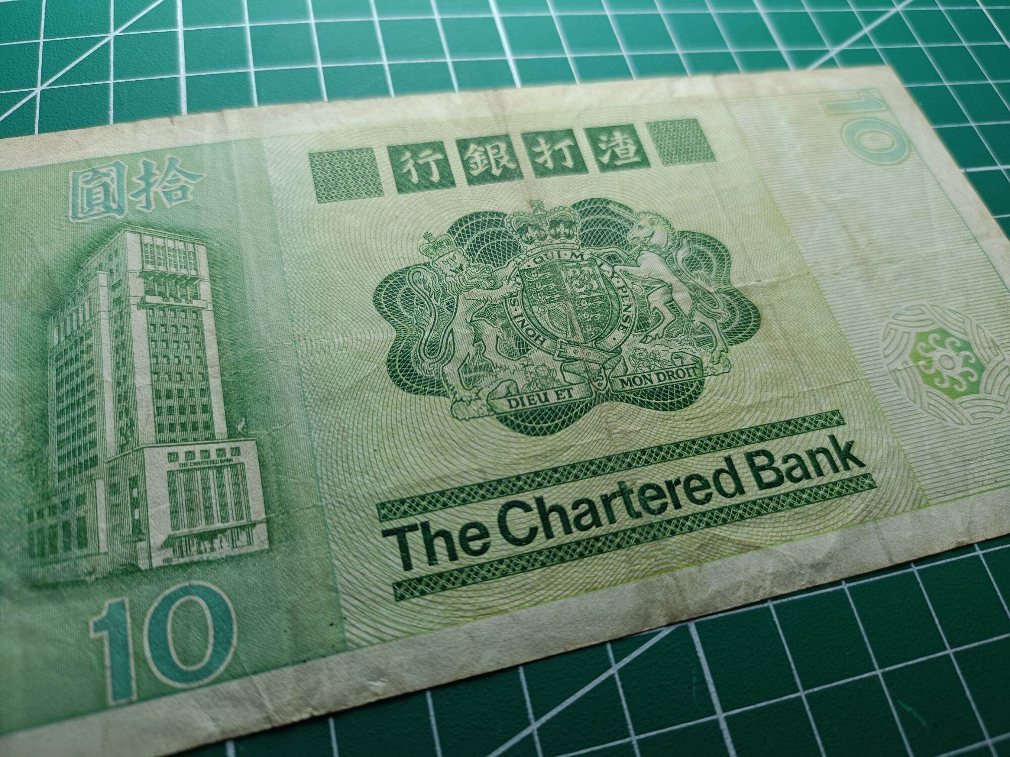 Hong Kong 10 Dollars ( 10 HKD) 1980 - 1981. Issues by Standard Chartered Bank ( Hong Kong). Green Multicolored underprint With Large Carp On The Right Hand Side.  Watermark. Helmeted Warrior's Head  Condition GVF. Nice Prefix : CM 245254. 
