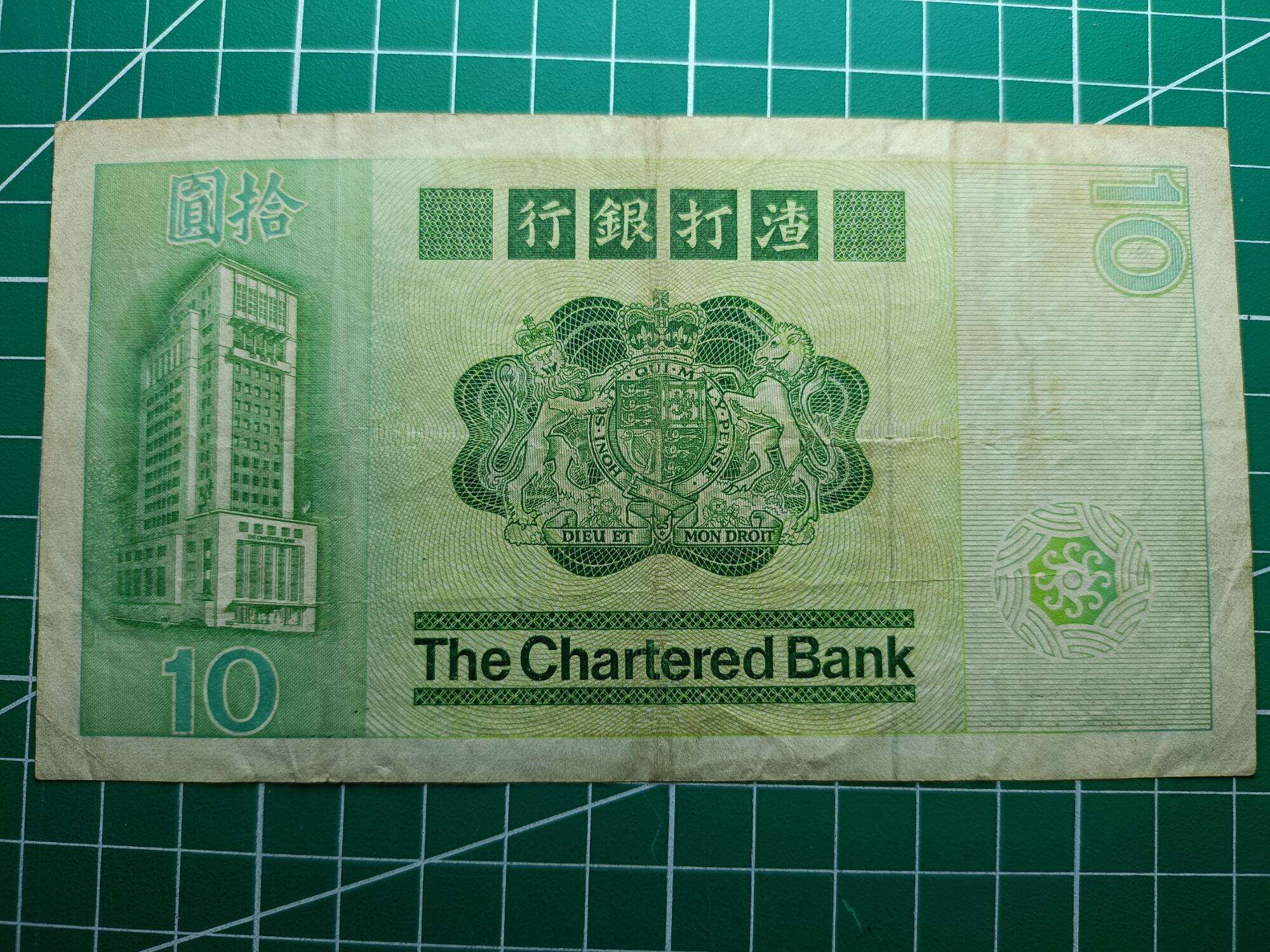 Hong Kong 10 Dollars ( 10 HKD) 1980 - 1981. Issues by Standard Chartered Bank ( Hong Kong). Green Multicolored underprint With Large Carp On The Right Hand Side.  Watermark. Helmeted Warrior's Head  Condition GVF. Nice Prefix : CM 245254. 