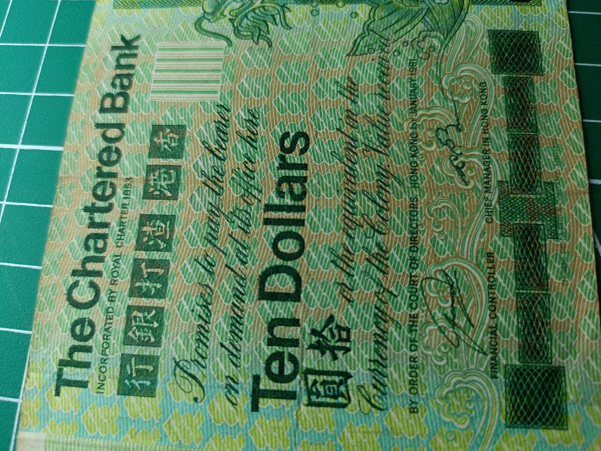 Hong Kong 10 Dollars ( 10 HKD) 1980 - 1981. Issues by Standard Chartered Bank ( Hong Kong). Green Multicolored underprint With Large Carp On The Right Hand Side.  Watermark. Helmeted Warrior's Head  Condition GVF. Nice Prefix : CM 245254. 